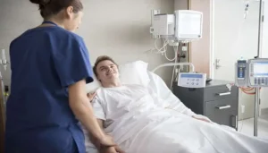 پرستار زن در حال گفتگو با بیمار مردی که عمل کرده است. عمل تاوی برای جوانان مناسب نیست.